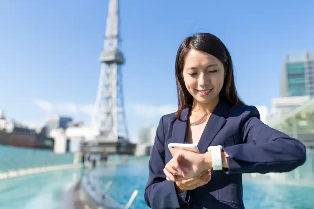Businesswoman Using Ultraminiature Switches on Mobile Phone And Smart Watch